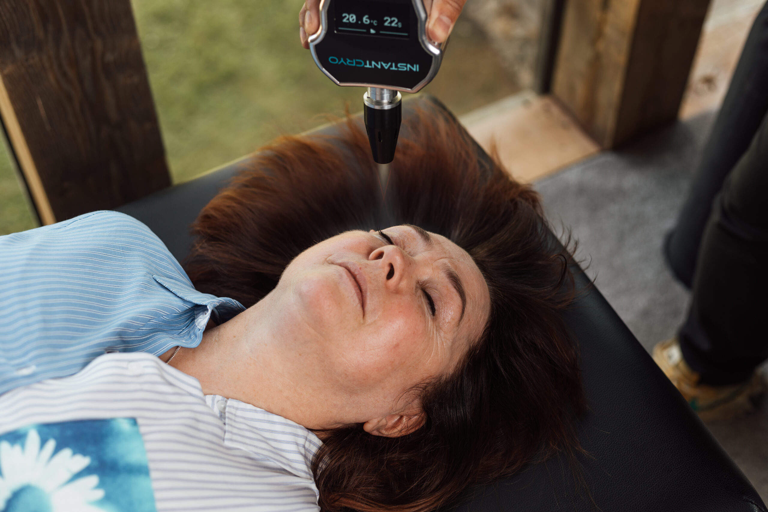 A cryo facial treatment is being applied to a woman's face. 